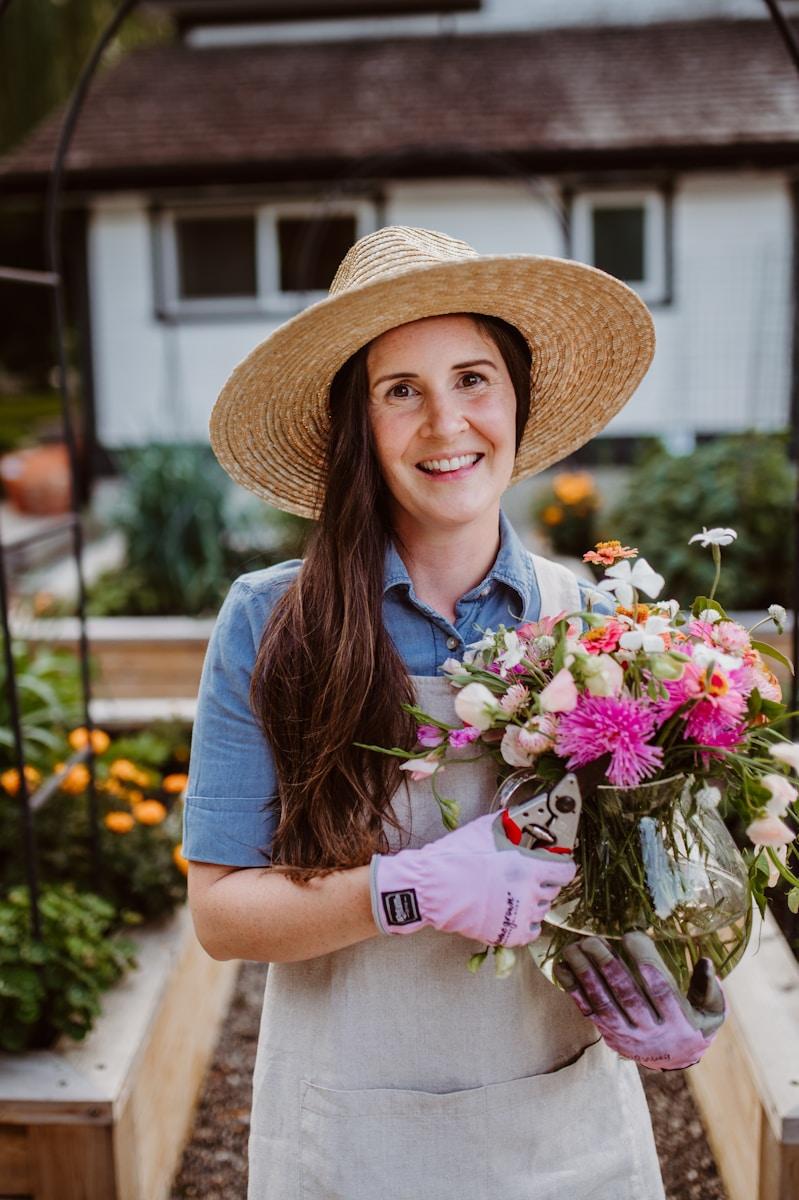 A woman holding a bouquet of flowers while a garden maintenance services in dubai